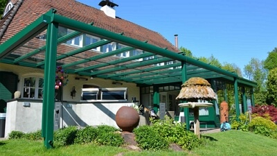 Eine sehr breite, grüne Terrassenüberdachung in Göttingen